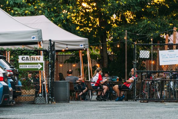 Image of white tents outside of Cairn Brewing, people seated, eating and drinking