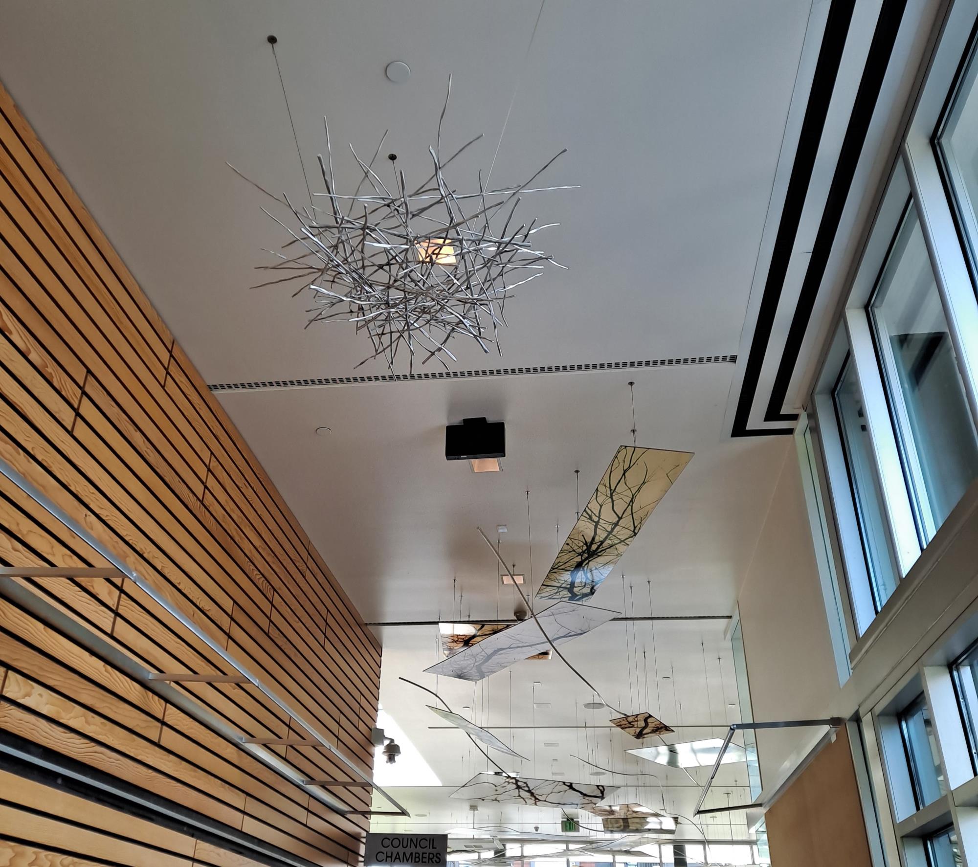 Metal nest and glass etched with trees mounted on the ceiling