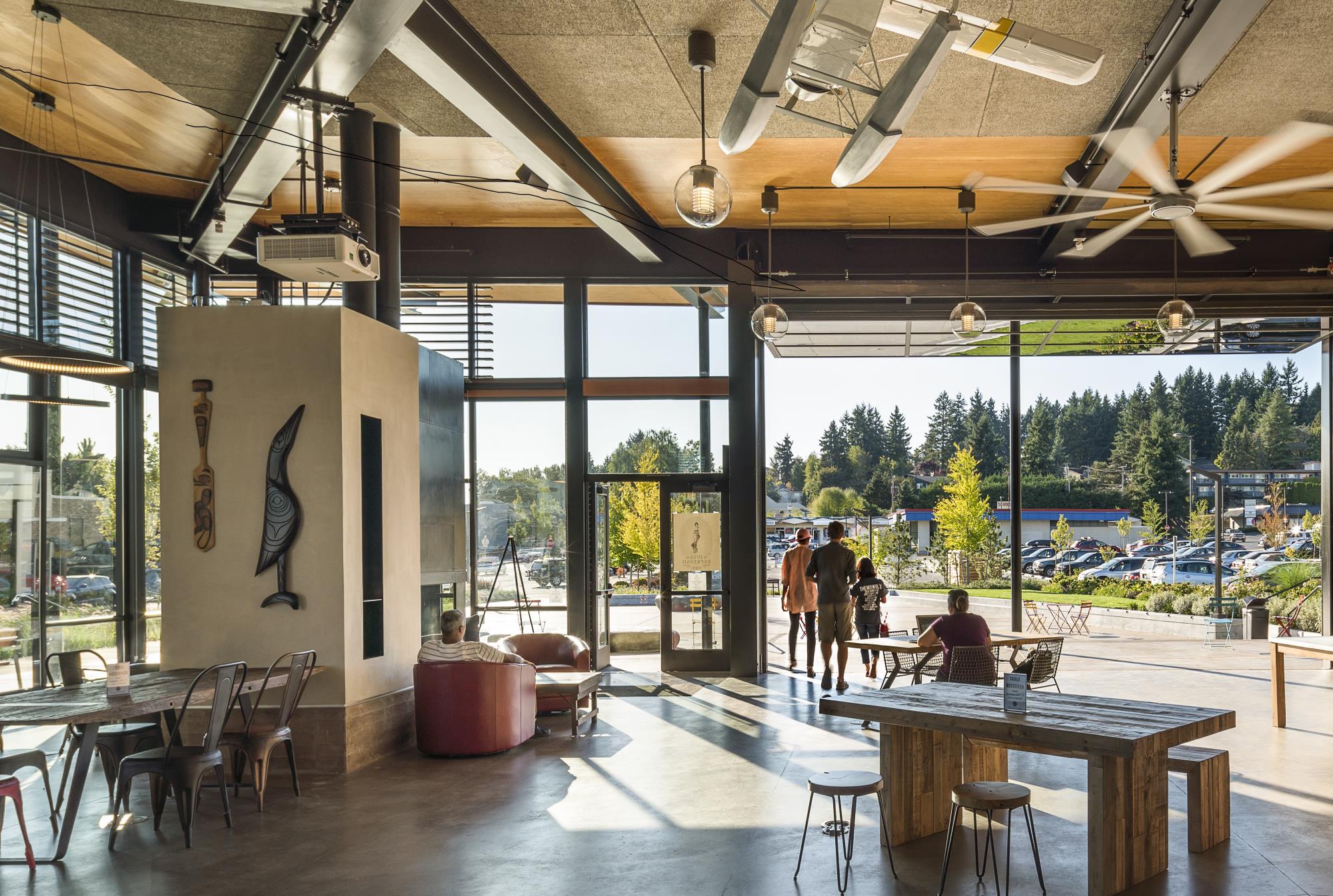 Wood carvings hanging on a wall in a space with tables and chairs