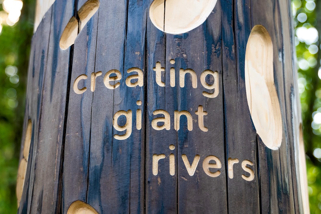 Carved Cedar Tree that says Creating Giant Rivers