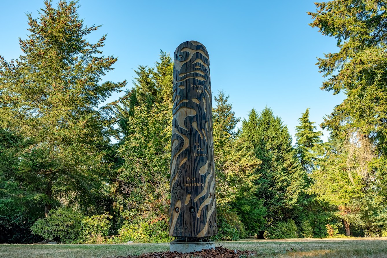 Carved Cedar Pole with words Every Tree in the Forest is a Fountain